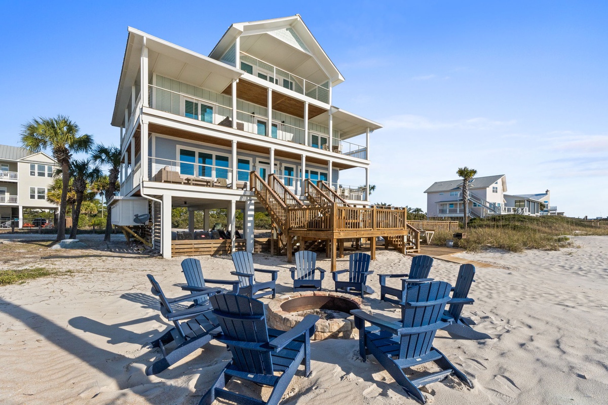 Stunning beachfront property with private fire pit and Adirondack chairs positioned directly on pristine sand.