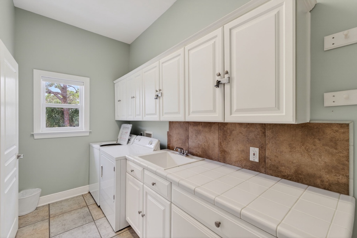 Your laundry tasks become effortless in this bright, organized space with ample storage and natural light.