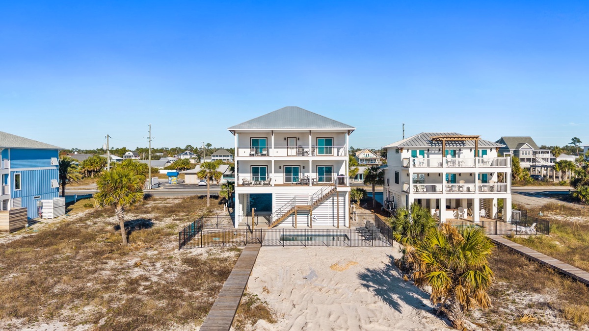 Elevated beachfront property with modern design and tropical landscaping in a coastal neighborhood setting.