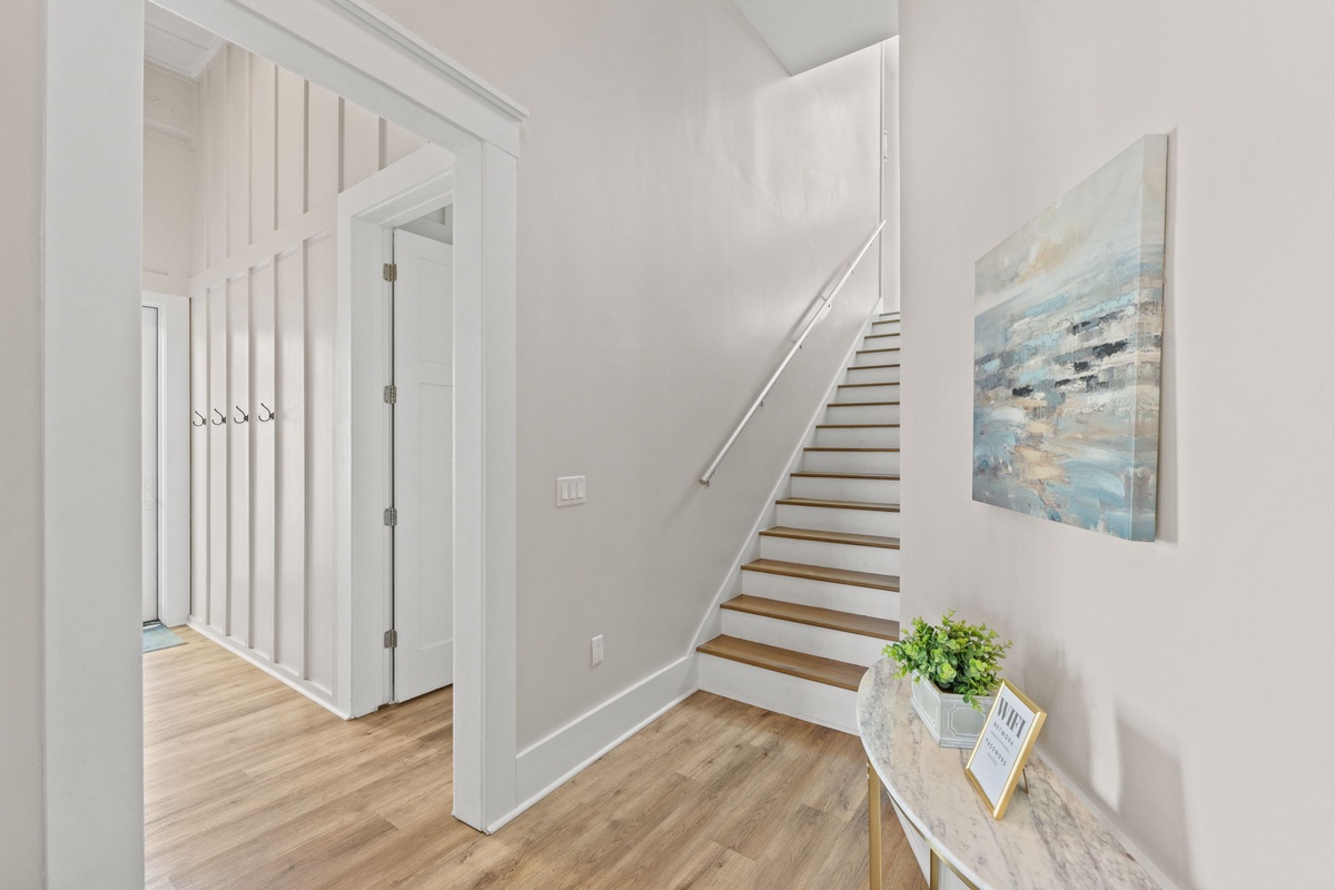 Step into your bright, welcoming entryway where coastal artwork and warm wood floors create an instantly calming atmosphere for your getaway.