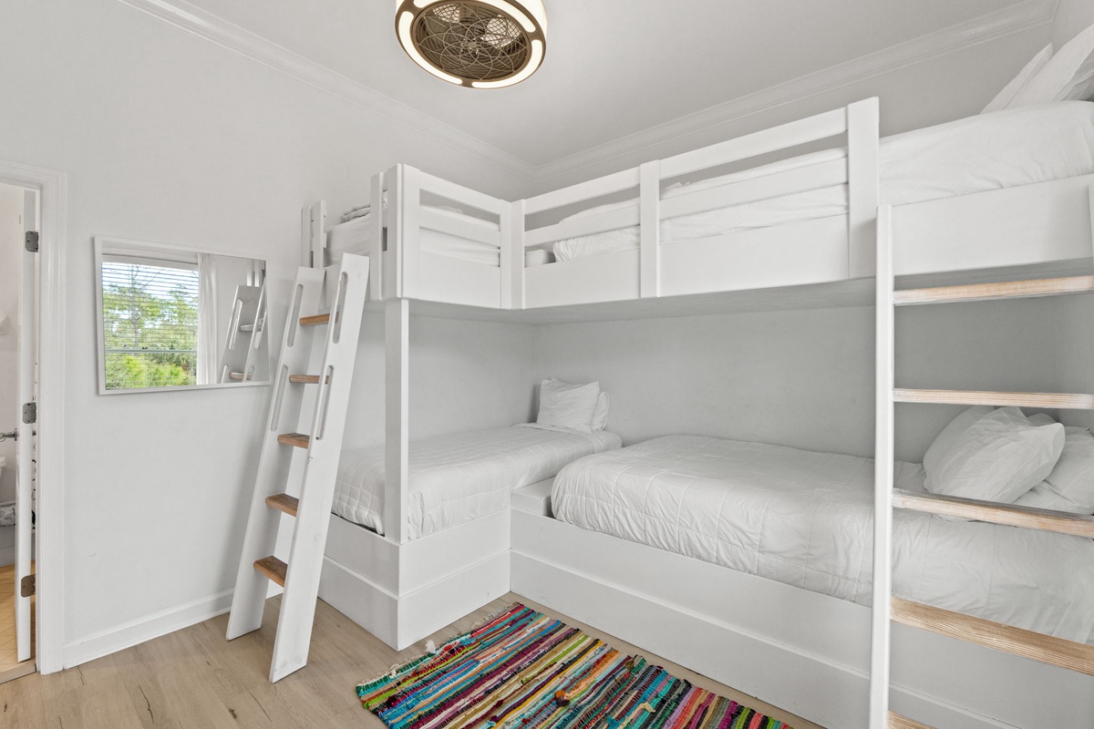 Your kids will love this cheerful bunk room with built-in beds and colorful rug, perfect for family adventures.