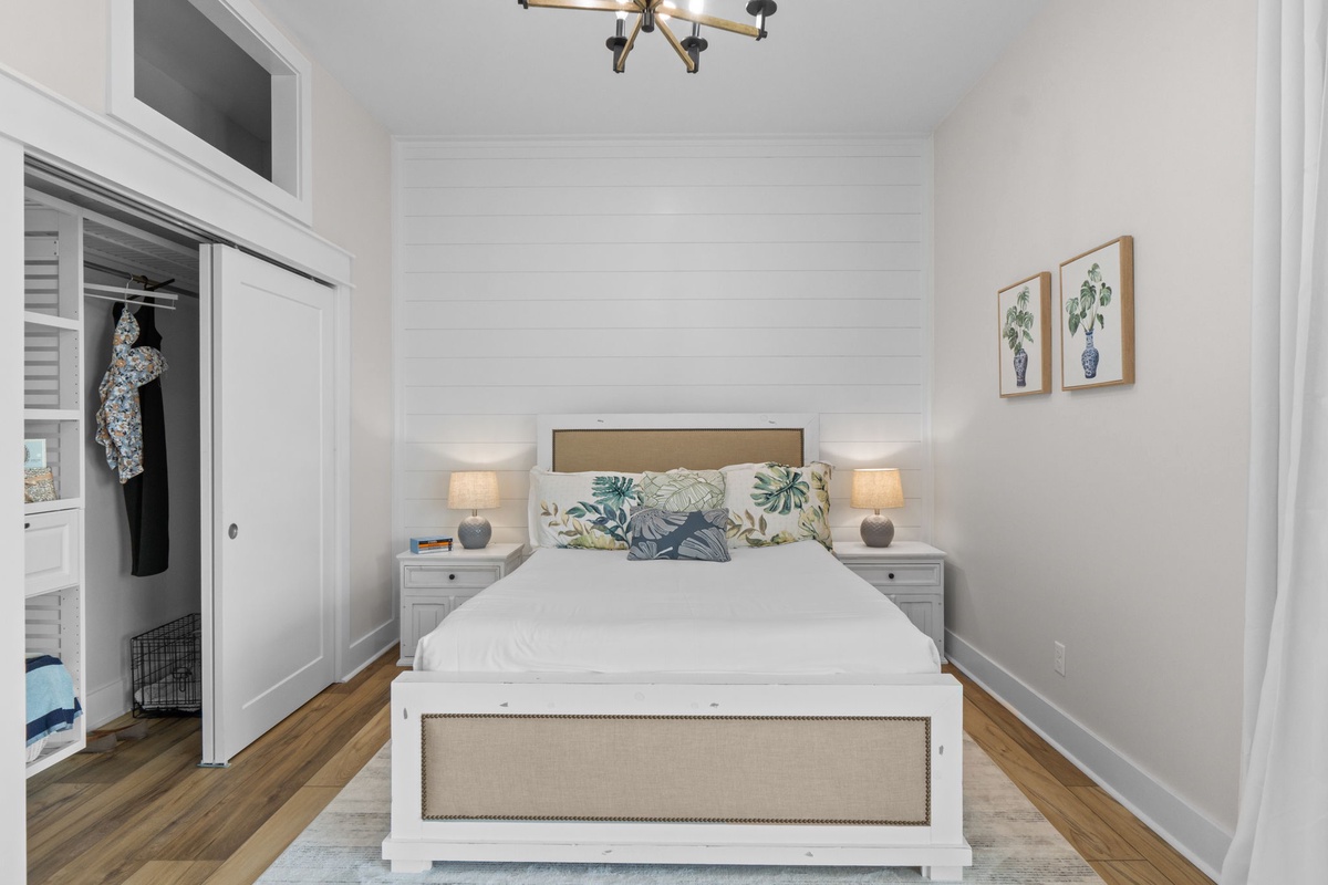 Unwind in your beautifully appointed bedroom where coastal-inspired linens and soft bedside lighting create a peaceful retreat. The crisp white shiplap accent wall and warm wood floors add charm to your restful sanctuary.