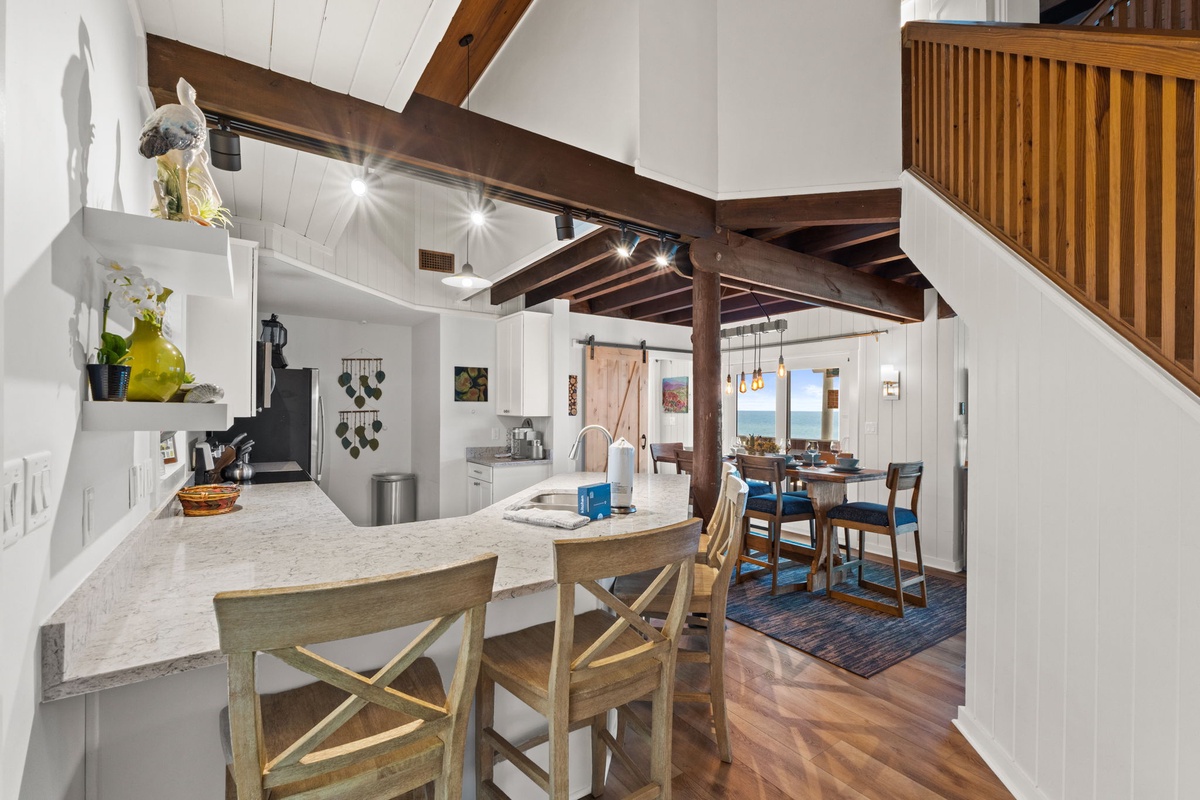 Step into this inviting open-concept space where natural light and warm wood tones create a welcoming retreat. The kitchen flows seamlessly into your dining area, perfect for gathering and making memories during your stay.