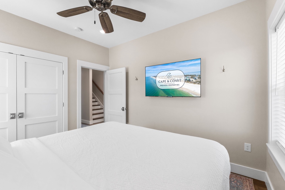 Drift off to sleep under gentle ceiling fan breezes in your serene bedroom, where coastal comfort meets modern style.