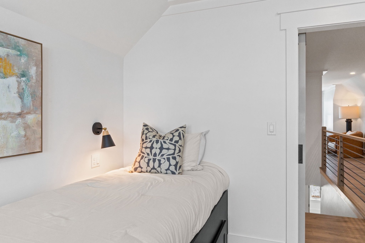 Unwind in your stylish bedroom with crisp white linens, artistic wall sconces, and thoughtful touches that create the perfect peaceful retreat.