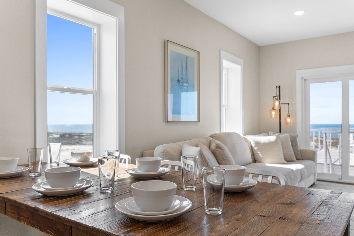 Your light-filled retreat features a beautifully set dining table and plush seating, where coastal breezes and ocean glimpses create the perfect backdrop for memorable meals.