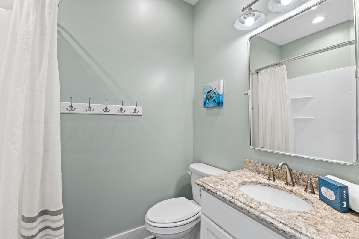Freshen up in this soothing bathroom with a spacious vanity, elegant granite countertop, and a bright, clean shower just steps away.