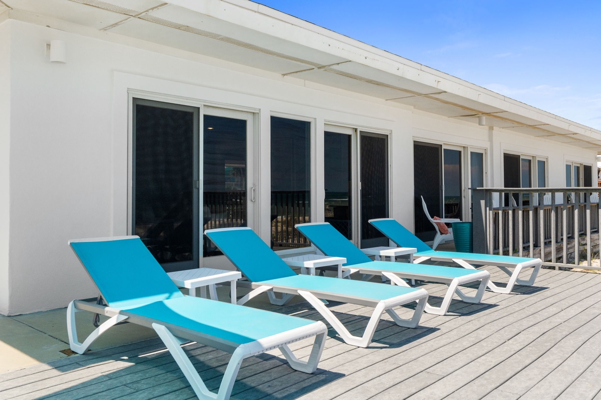 The sunlit deck awaits your sun-soaked mornings and lazy afternoon lounging, steps from your vacation home. Pull up a lounger, feel the ocean breeze, and let all your worries fade.