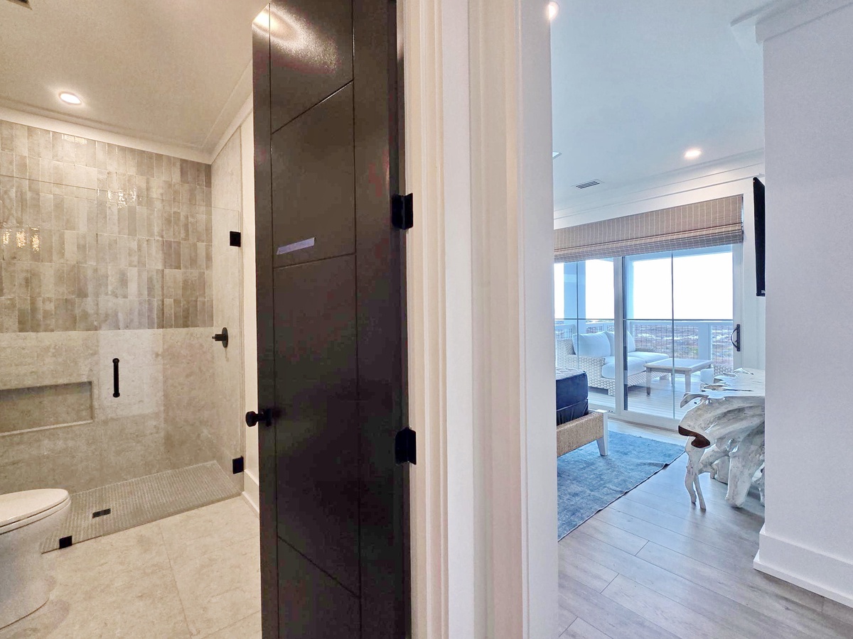 Your spa-like bathroom features a luxurious walk-in shower with elegant tile work, connecting seamlessly to your bedroom retreat.