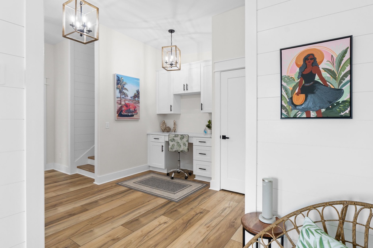 A welcoming entryway with crisp white shiplap walls, warm wood floors, and custom cabinetry—your perfect spot to settle in after a day exploring the coast.