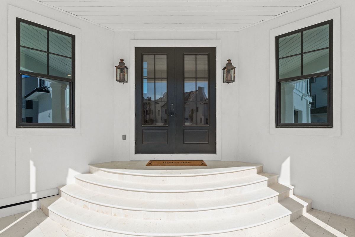 Elegant curved steps lead to your private entrance, framed by classic lanterns and welcoming glass doors that invite you home.