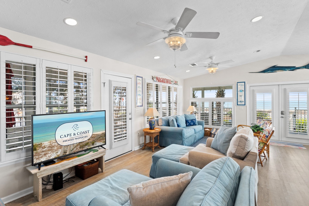 Unwind in your bright coastal living room with nautical ceiling fans, comfy seating, and multiple windows with plantation shutters.