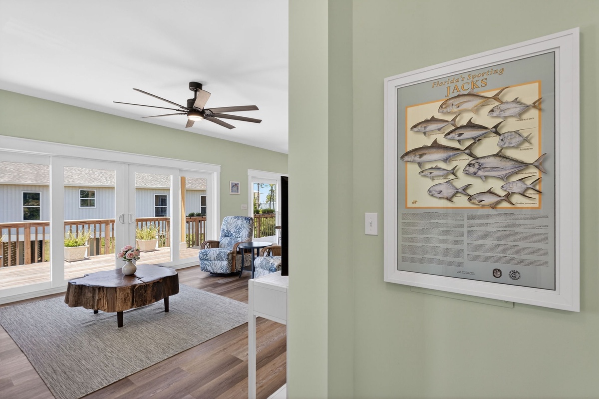 You'll love the breezy coastal charm of this sunlit living space, where natural wood and soft green walls create a calming retreat after a day of seaside adventures.
