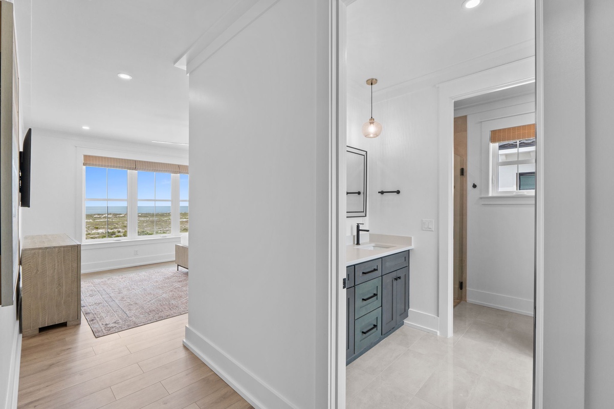 Clean lines and modern finishes define your private bathroom, with a tasteful vanity and serene coastal views beyond—thoughtfully designed for your comfort and style.