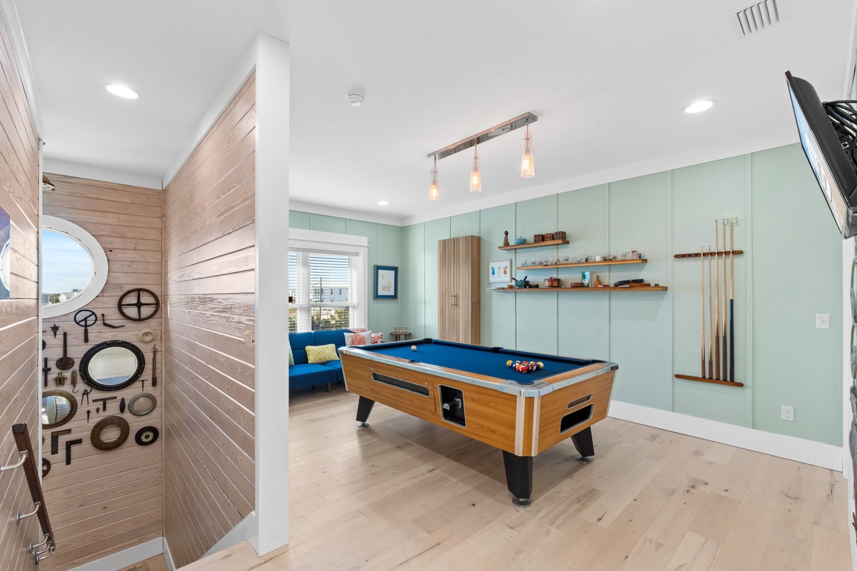 Your private game room awaits with a pristine pool table, coastal charm, and everything you need for friendly competition.