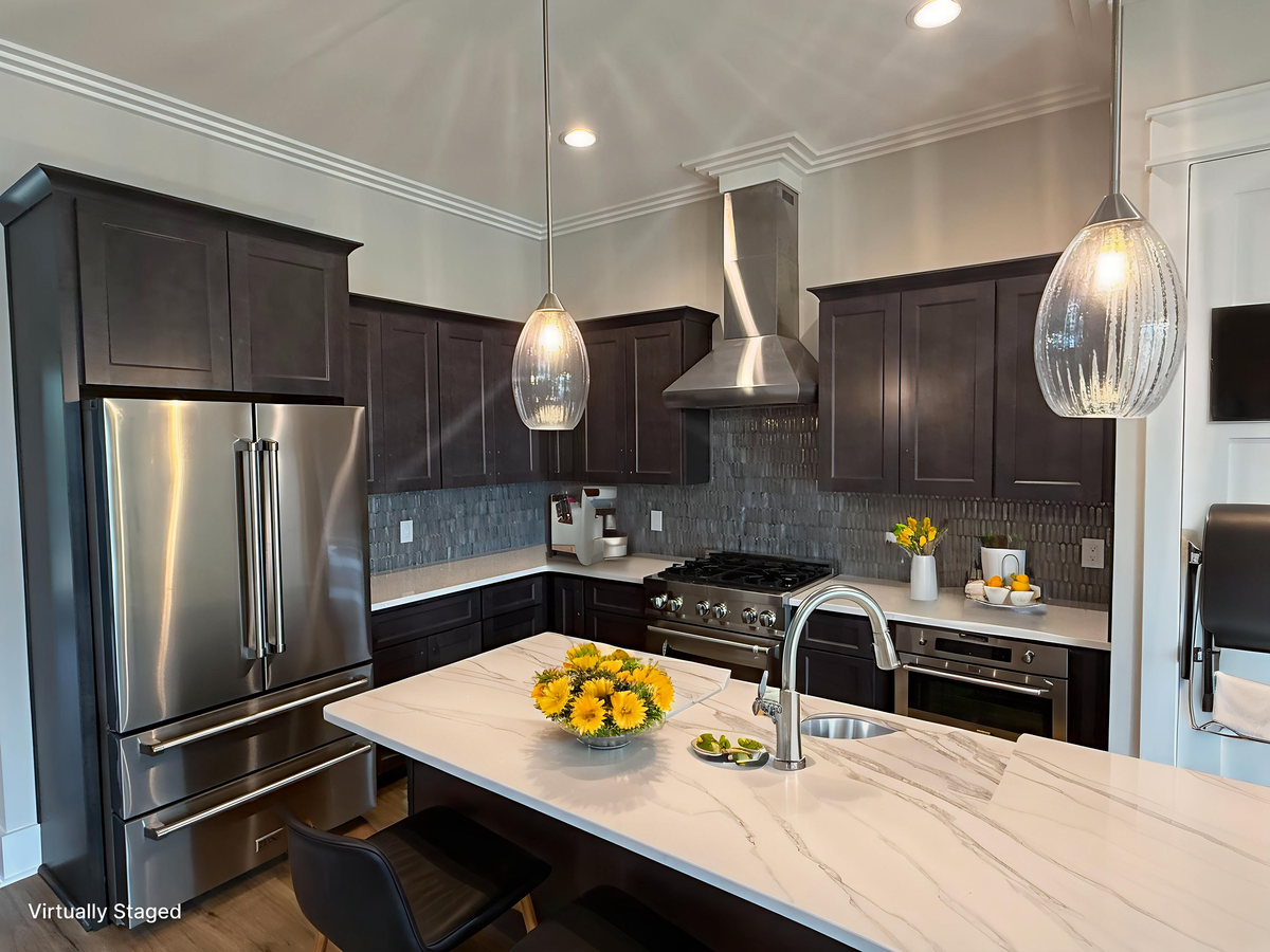 Your gourmet kitchen awaits with gleaming stainless steel appliances, elegant pendant lighting, and marble countertops perfect for preparing memorable meals.