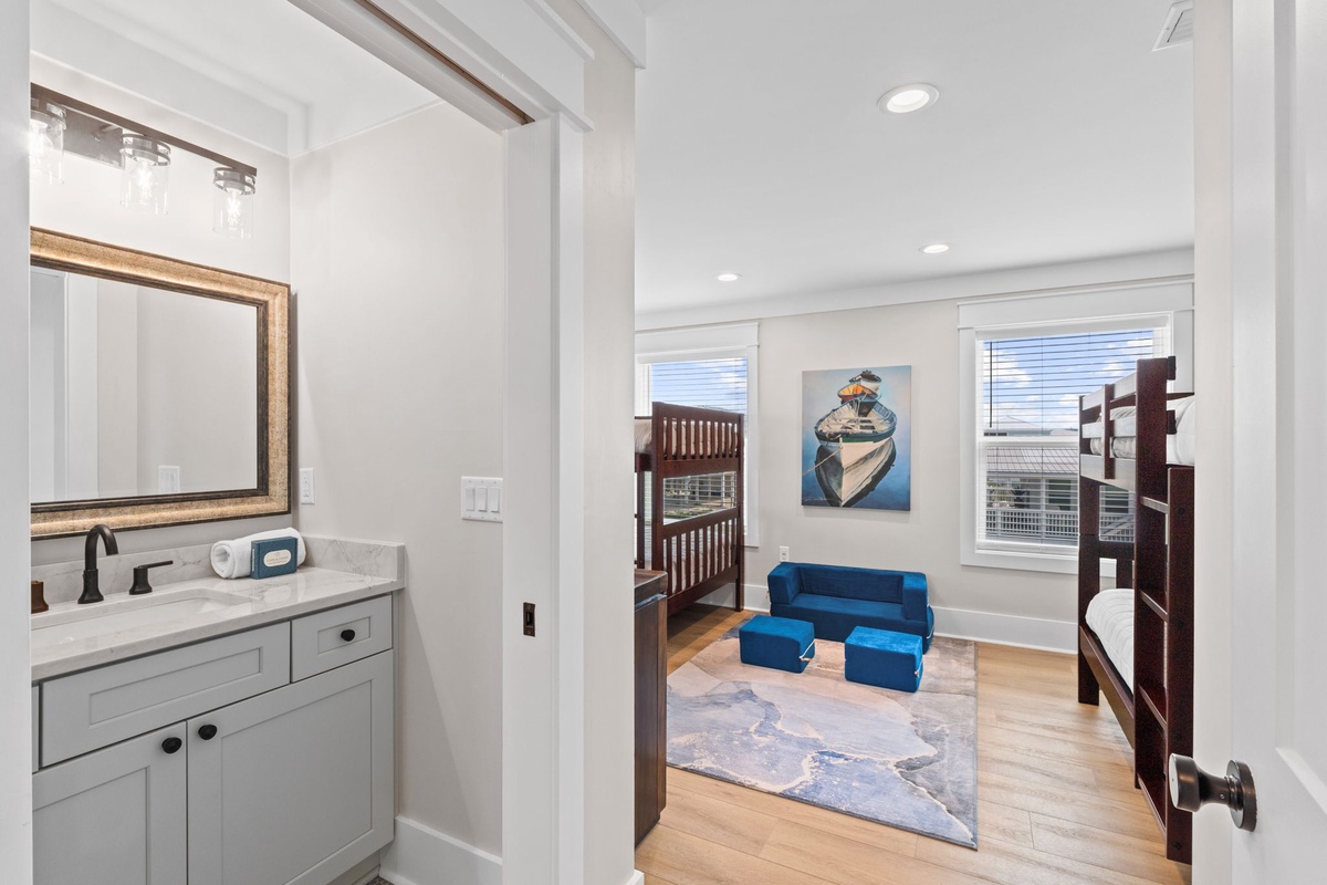 Your home away from home features a charming bedroom with custom bunk beds and a cozy seating nook, plus a pristine en-suite bath—perfect for families seeking comfort and style.