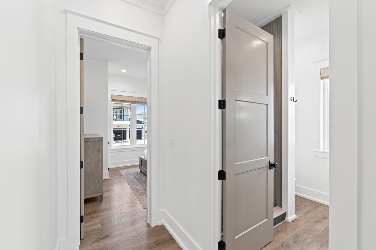 Step into your stylishly appointed hallway featuring warm hardwood floors and crisp white trim that connects your private spaces seamlessly.