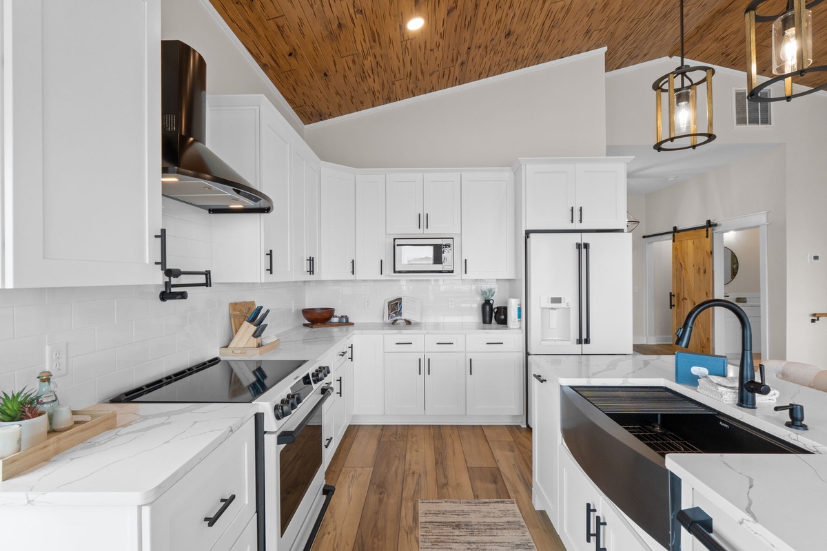 Modern kitchen with bright cabinetry, sleek appliances, and warm wood accents. Perfect for preparing meals and gathering with loved ones.