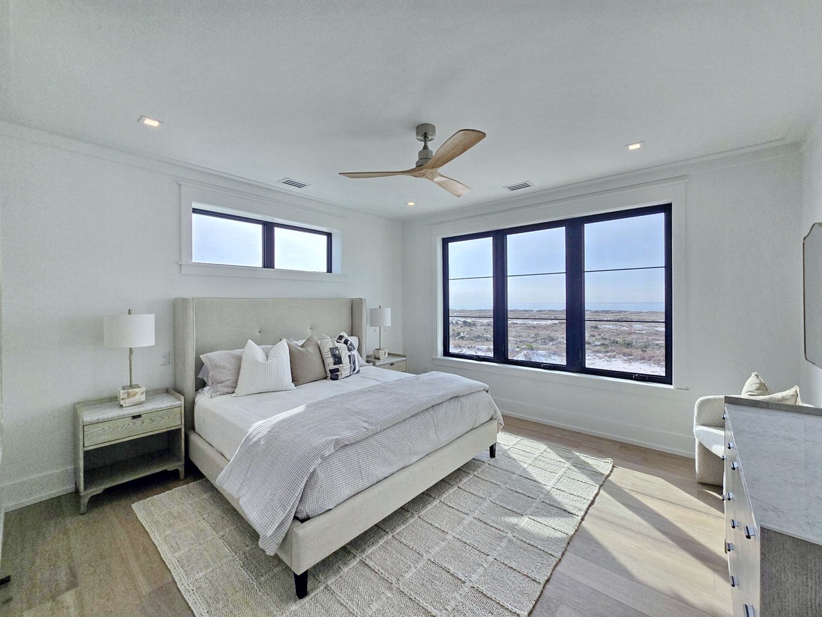Drift off to sleep in this serene bedroom where panoramic windows frame sweeping desert views, while soft linens and modern comfort create your perfect retreat.