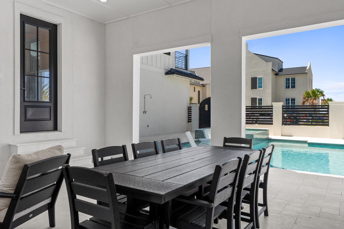 Dine al fresco at your covered patio, where the spacious outdoor table invites leisurely meals by the pool. Relax in this serene, private setting with refreshing water views.