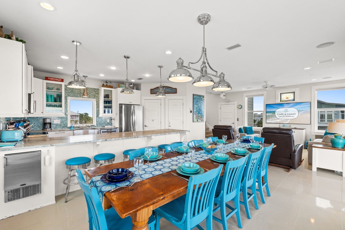 Your bright, open kitchen flows seamlessly into the dining area, where turquoise chairs invite memorable meals together.