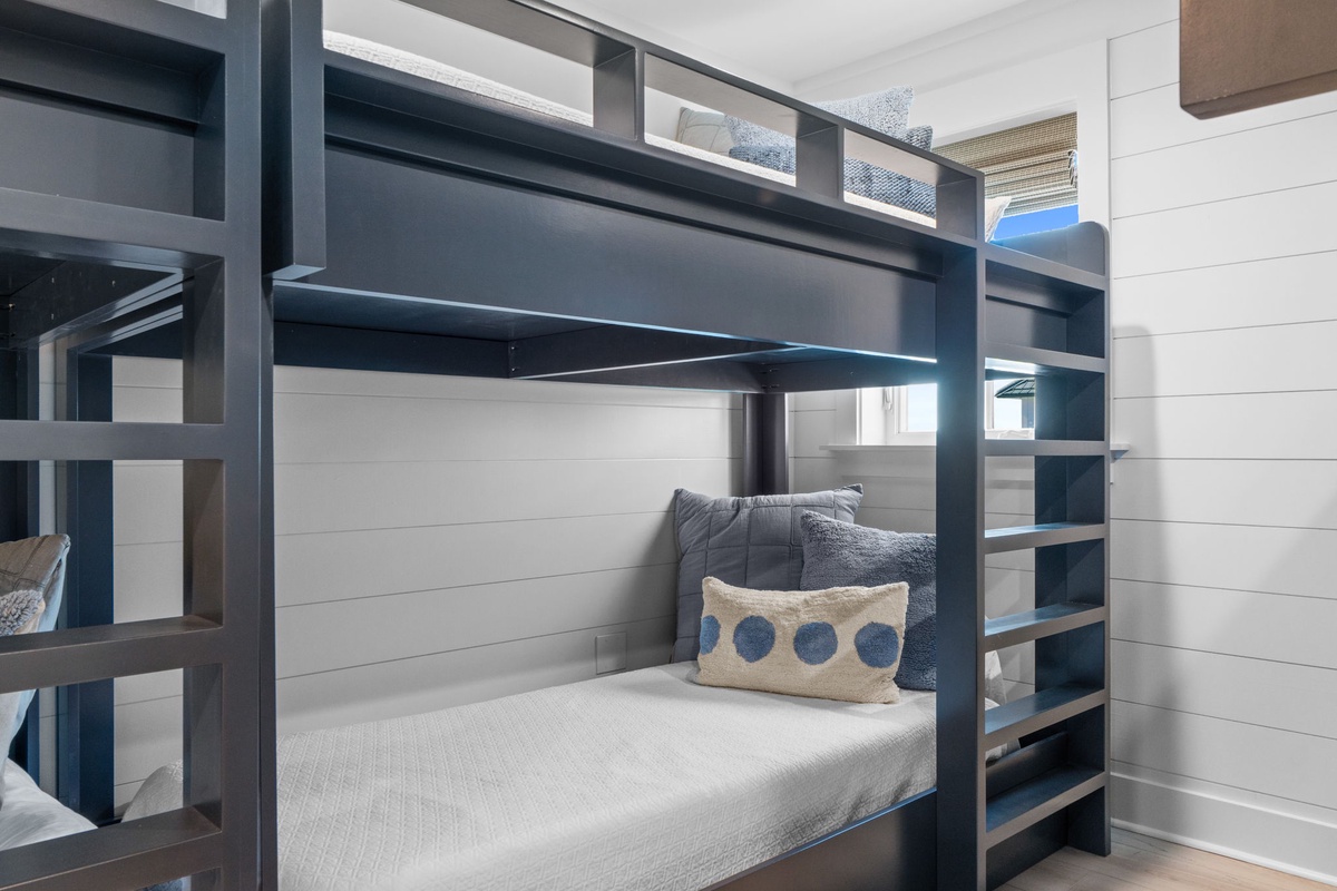 Cozy up in your private bunk with soft linens and thoughtful touches—perfect for restful nights in this stylish shared space.