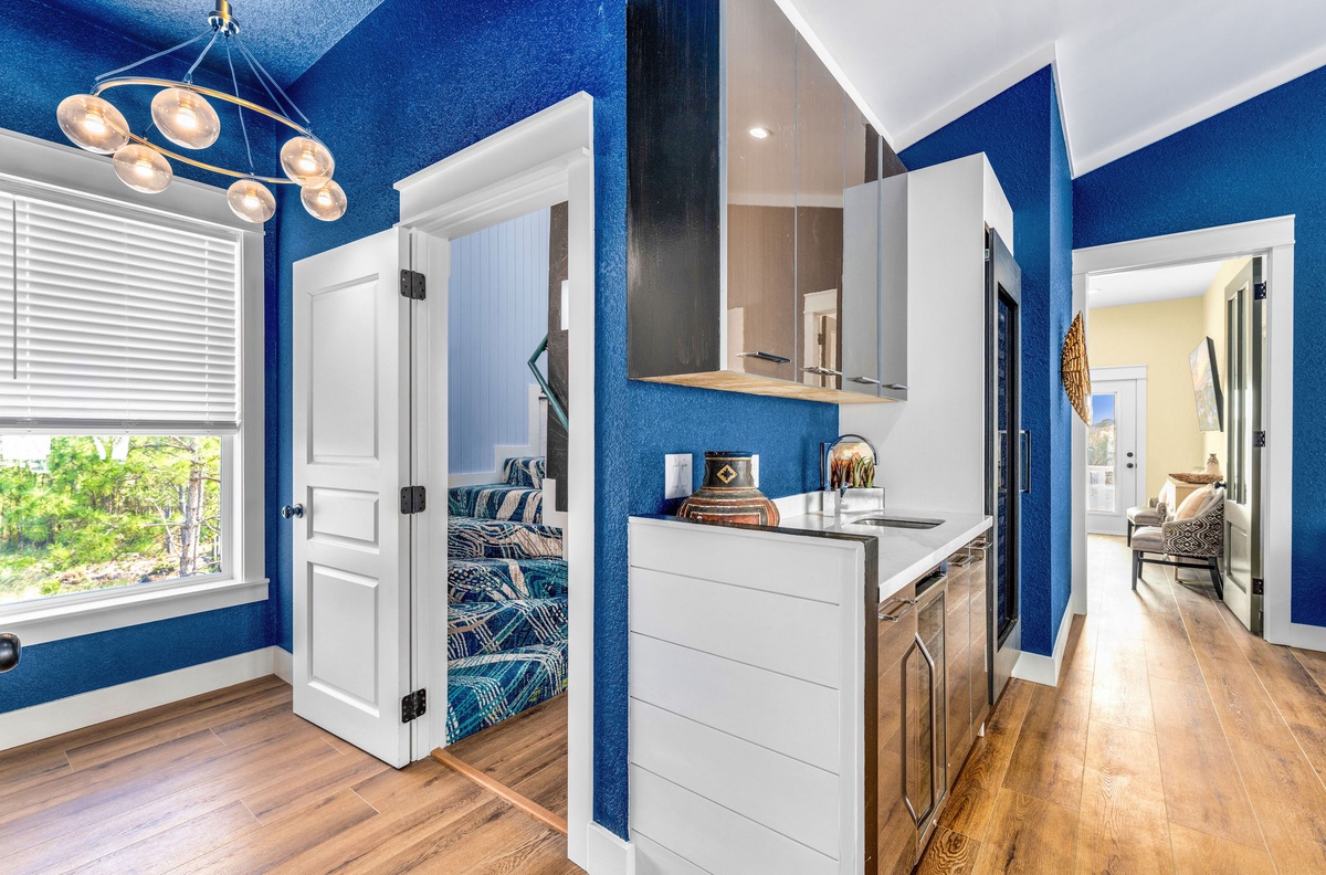 Step into your vibrant blue sanctuary with gleaming hardwood floors, modern kitchen, and cozy seating nook bathed in natural light.
