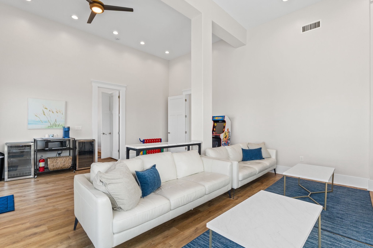 Unwind in your stylish living room featuring plush white sofas, a sleek entertainment area, and modern touches throughout this bright, airy space.