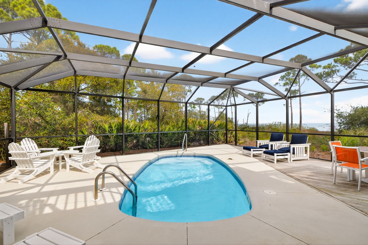Dive into your private screened pool sanctuary, where comfortable seating and tropical views create the perfect escape for relaxation.