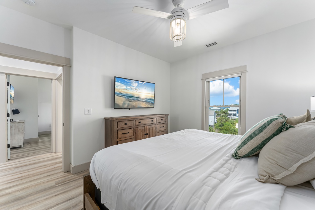 Drift off in your bright, airy bedroom with crisp linens, coastal artwork, and gentle ceiling fan breezes creating the perfect retreat.