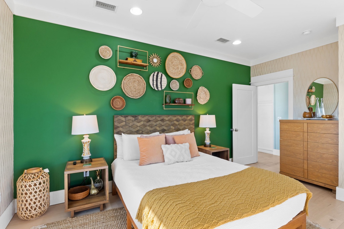 Drift off to sleep in this vibrant bedroom where the bold emerald accent wall and curated basket collection create your own artistic retreat.