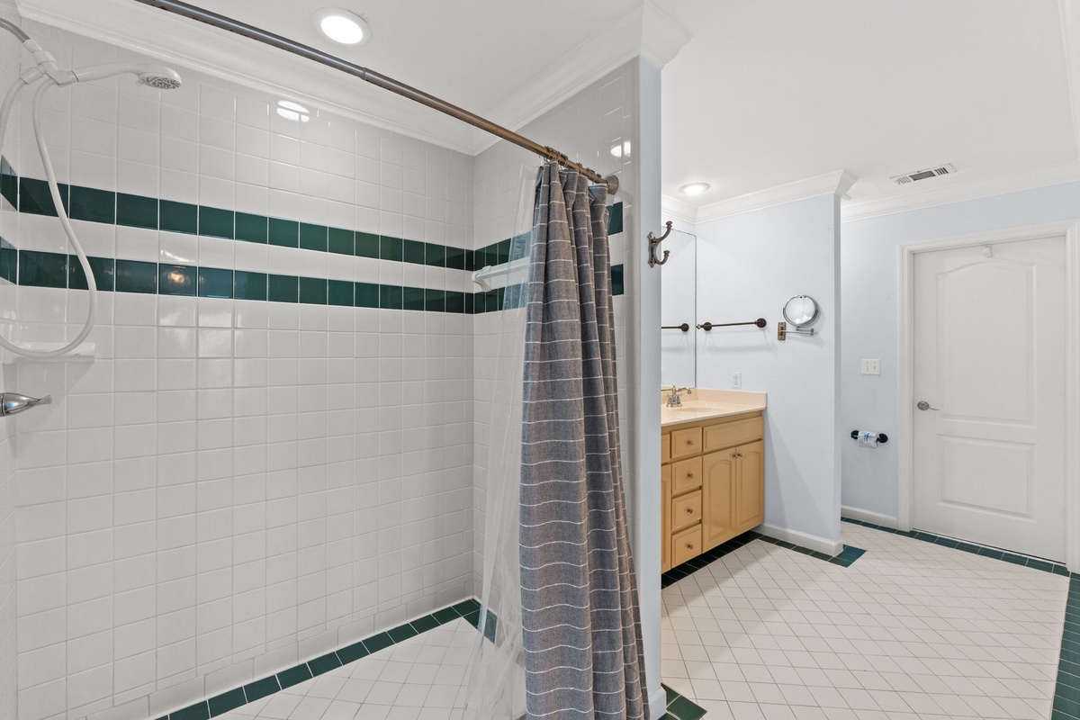 Step into your spacious bathroom with cheerful tiled accents and a refreshing walk-in shower for your daily rituals.