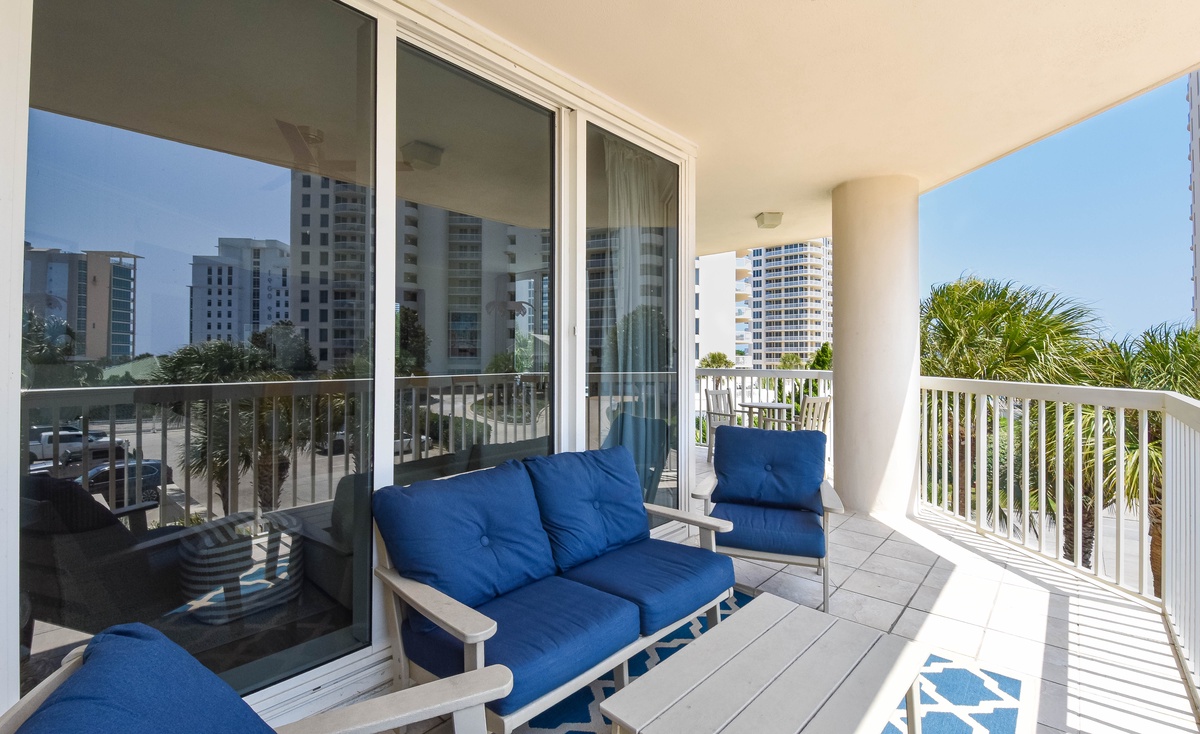 This covered balcony features comfortable seating where you can unwind with tropical views, city skyline vistas, and refreshing outdoor air—all from your private retreat.