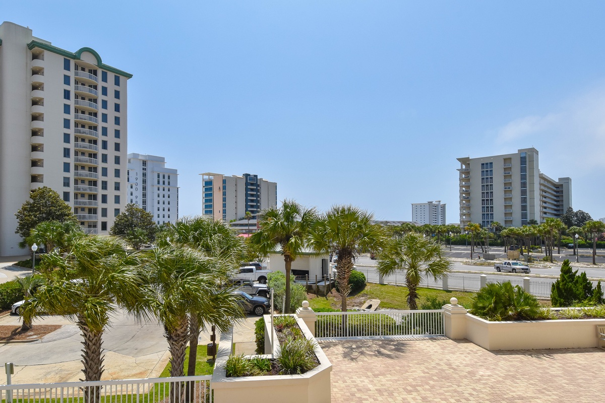 Coastal vacation property situated in a landscaped beachside community with palm-lined streets, nearby high-rise buildings, and convenient access to local attractions and amenities.