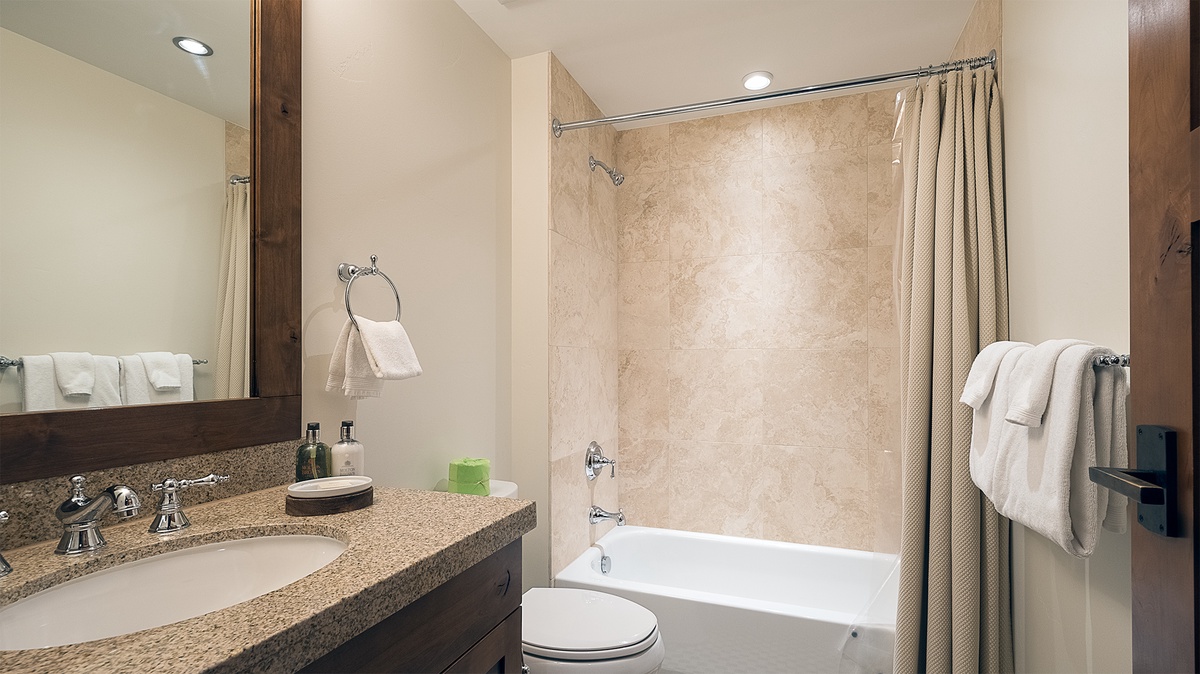 Shared Bathroom, Main Level - Hall bathroom adjacent to Bedroom 4 with single vanity and shower/tub combo