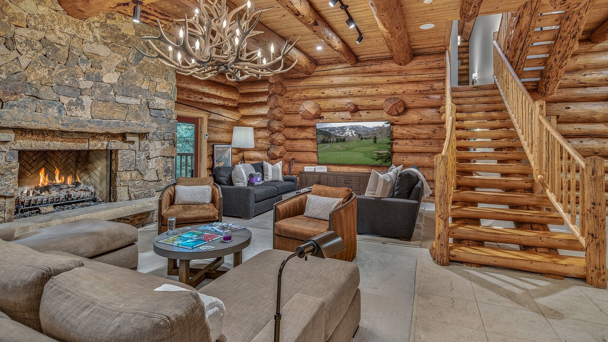 Great Room, Main Level - Seating area with stone fireplace beside staircase