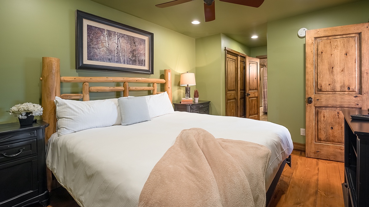 Slip into crisp white linens and rustic charm in your serene retreat. The warm wood tones and soft bedding promise a restful night's sleep in this cozy bedroom.