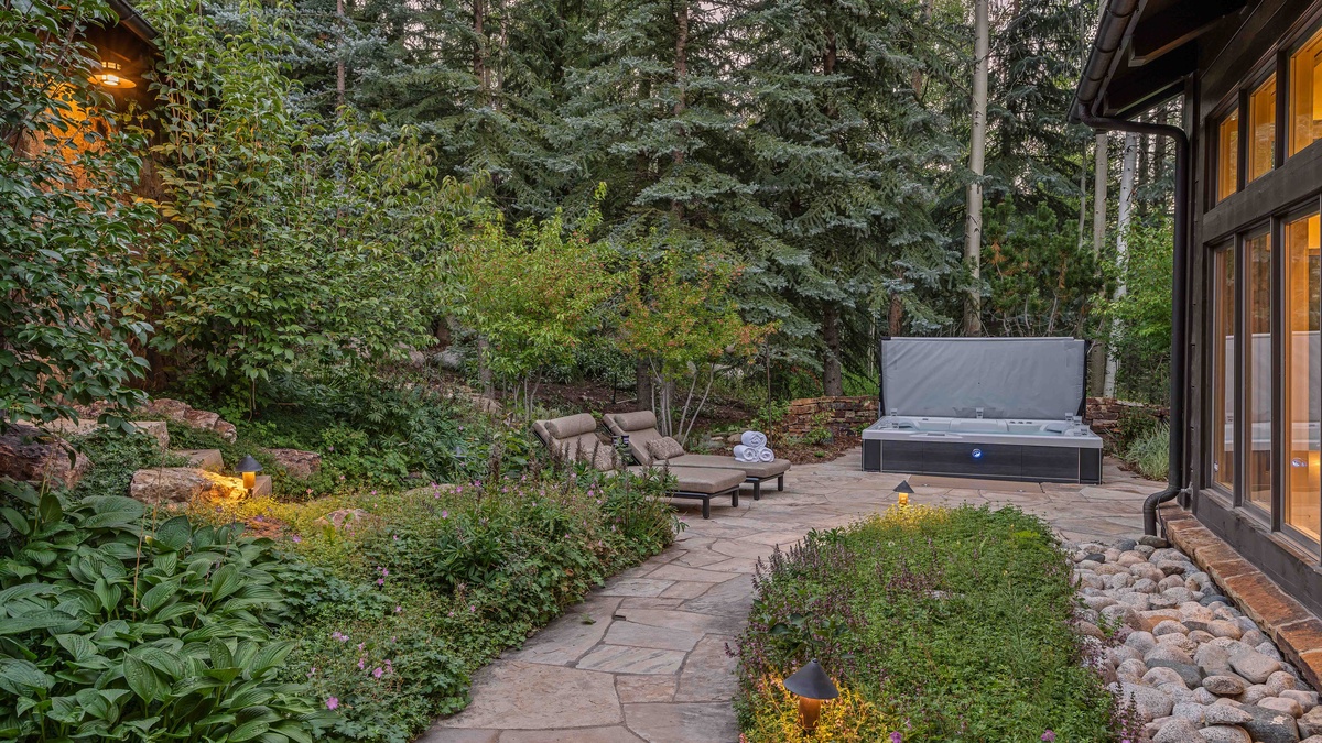 Dreamy back patio with hot tub and lounge chairs