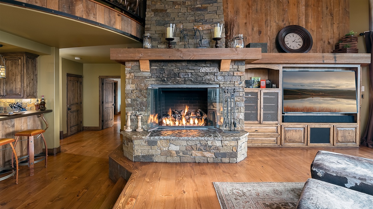 Warm up by the stunning stacked-stone fireplace in your spacious living area, where rustic wood beams and cozy furnishings invite you to relax after a day of exploring.