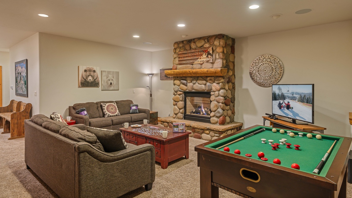 Family room on lower level with fireplace and TV