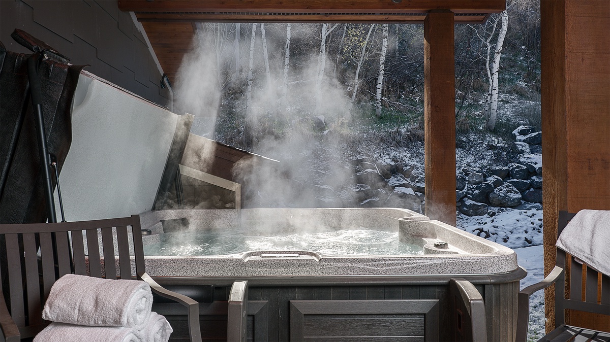 Sink into steaming bliss in your private hot tub, surrounded by snow-dusted birches and a rocky winter stream—pure mountain serenity at your fingertips.