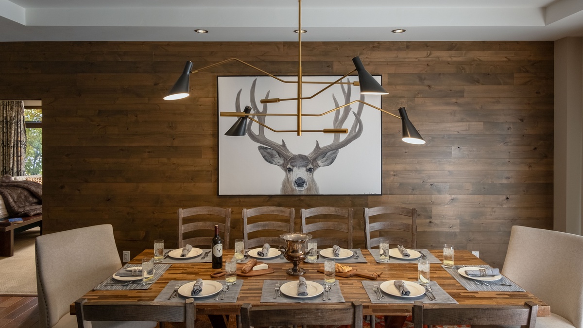 Dining Area, Main Level - Dining table beneath modern chandelier and wood accent wall