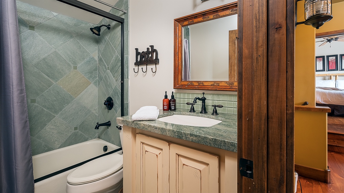 Unwind in your private bathroom featuring a soothing tiled shower, elegant fixtures, and rustic touches that blend style with everyday comfort.