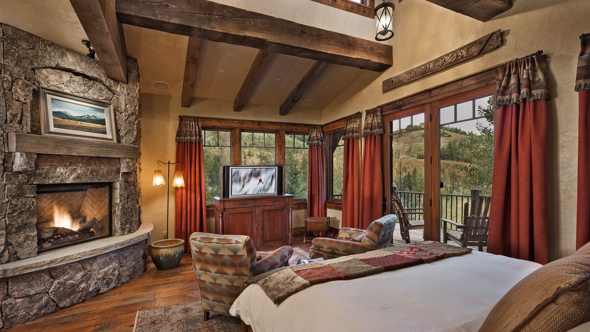 Primary suite on main level with sitting area, TV, fireplace and private deck