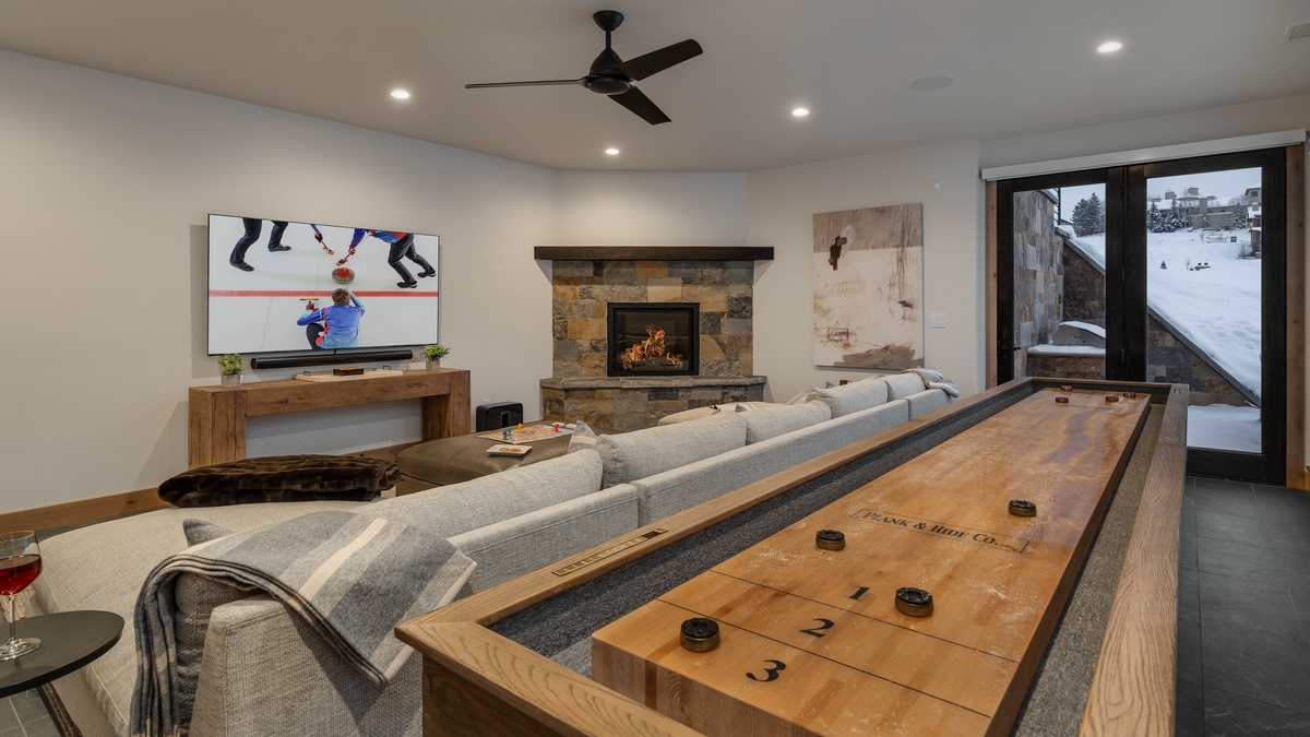 Downstairs family room with shuffleboard and fireplace