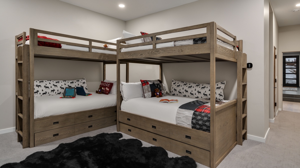 Bunk bedroom on lower level has a TV and deck access