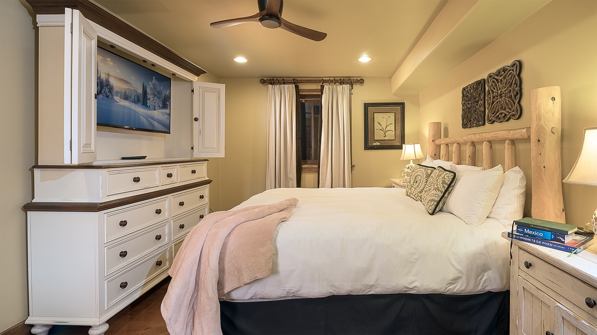 Sink into soft linens and a plush bed in this cozy bedroom, where warm lighting and thoughtful details create your perfect mountain retreat for restful nights.