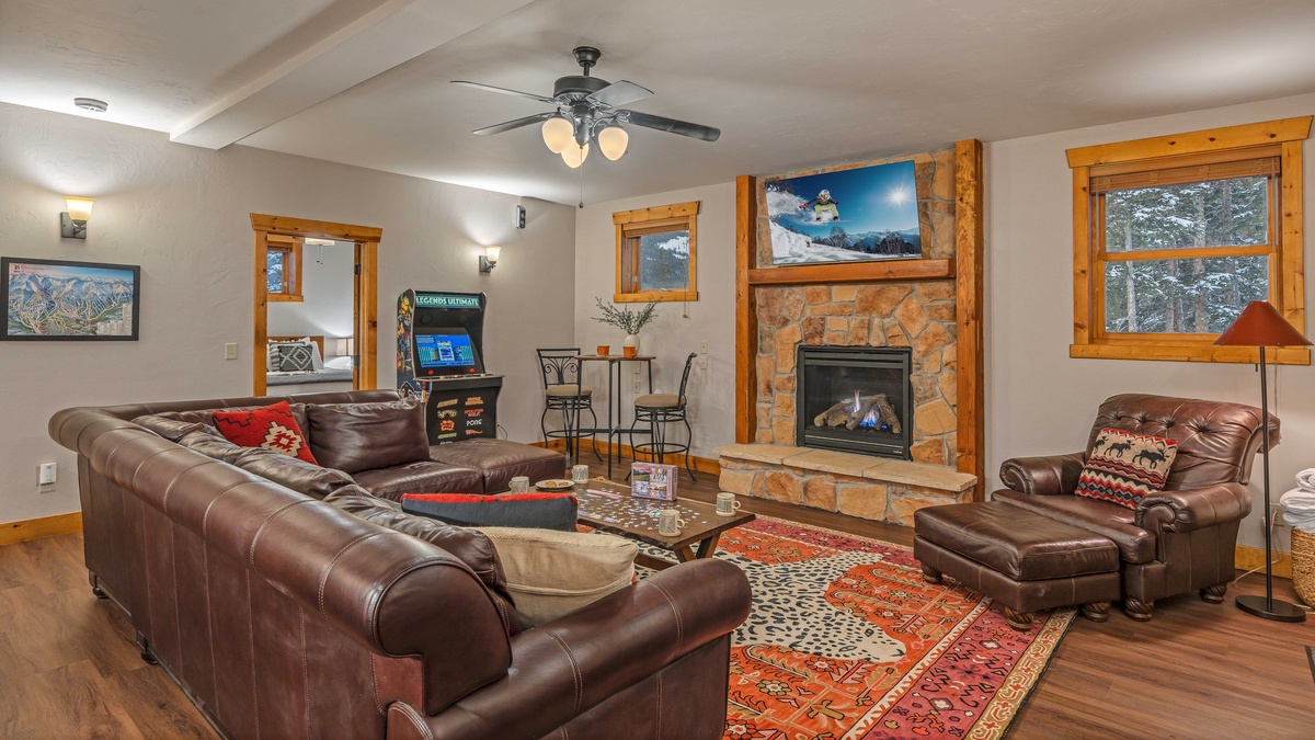 Lower level family room with gas fireplace, TV, and arcade game
