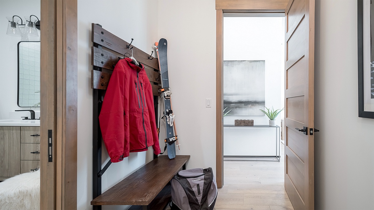 Lower Level - A hallway area with wall hooks and bench for storage